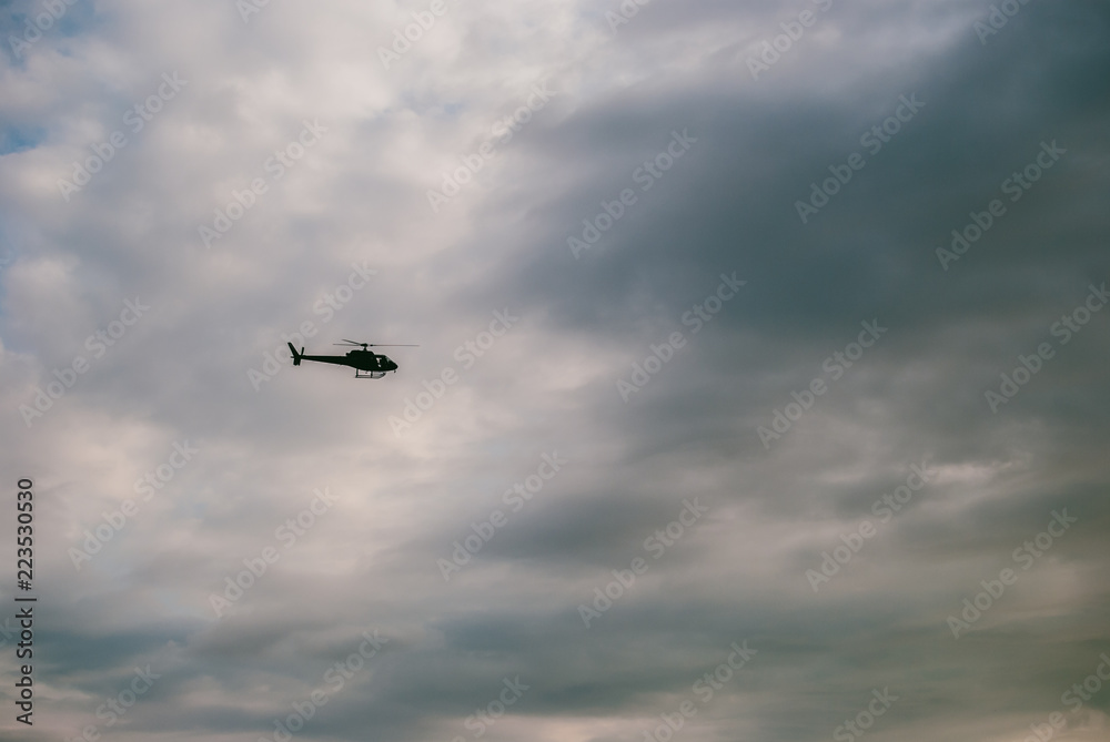 Silhouette of a helicopter flying in the twilight sky