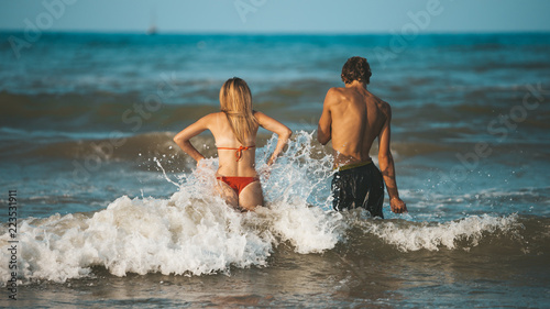 Canvas Print Young happy and sportive couple bathing in Adriatic sea in Rimini (Italy) - spor