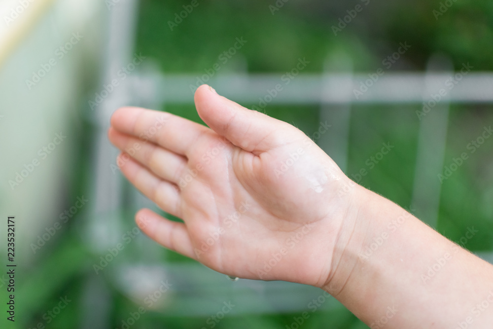 A child's hand catches a drop of water. A child's hand catches a drop of water.