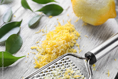 Bilde på lerret Grater with fresh lemon zest on wooden board
