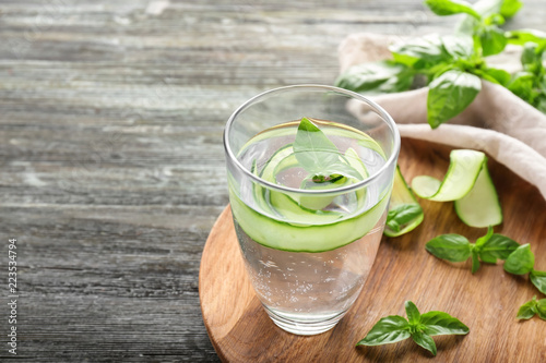 Glass of cucumber infused water on wooden table