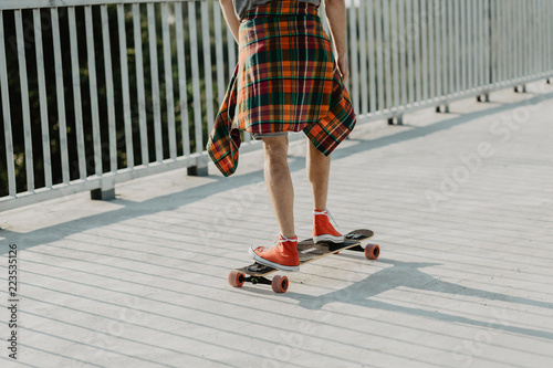guy in red  sneakers and checkered shirt ride a skateboard. sport