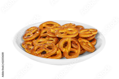 Snack, cookies, salted biscuit, brezel, bretzel to beer in front of alcohol on plate, white isolated background Side view. For the menu, restaurant, bar, cafe