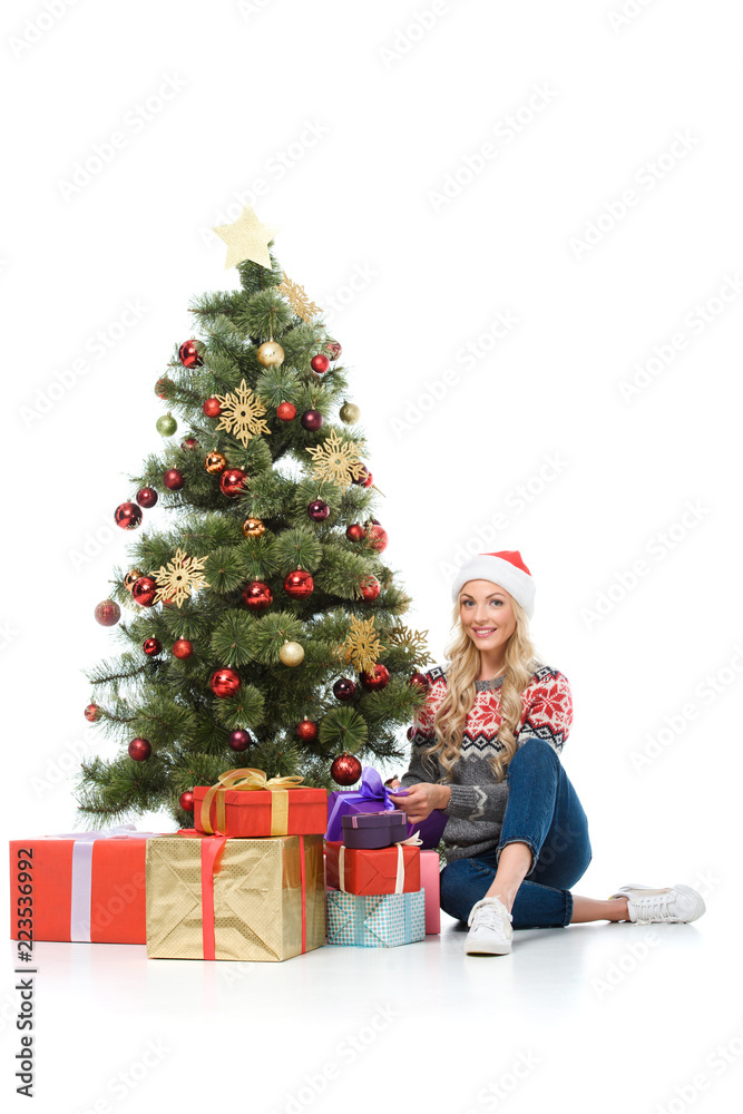 beautiful woman putting gift boxes under christmas tree, isolated on white