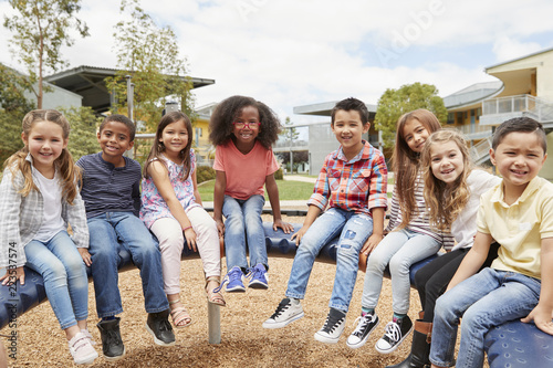 Elementary school kids sitting on carousel in the schoolyard