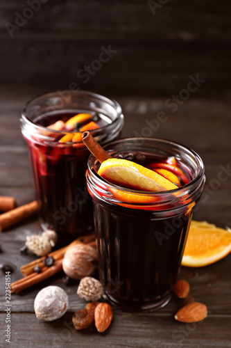 Jars of delicious mulled wine on wooden table