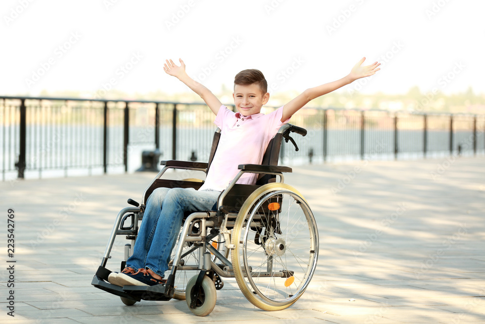 Happy boy in wheelchair outdoors Happy boy in wheelchair outdoors
