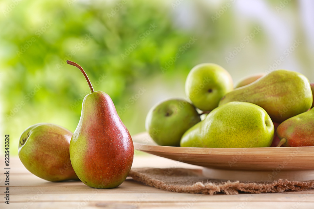 Plate with ripe pears on table against blurred background Plate with ripe pears on table against blurred background