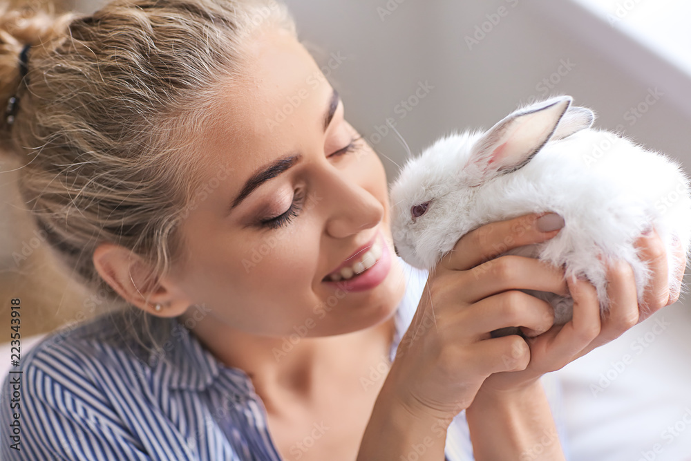 Beautiful young woman with cute rabbit at home Beautiful young woman with cute rabbit at home