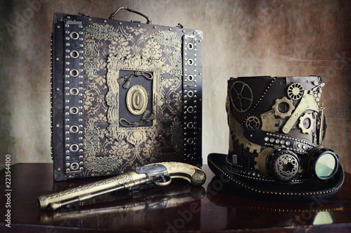 Steampunk,cappello a ingranaggi,valigetta e pistola photo