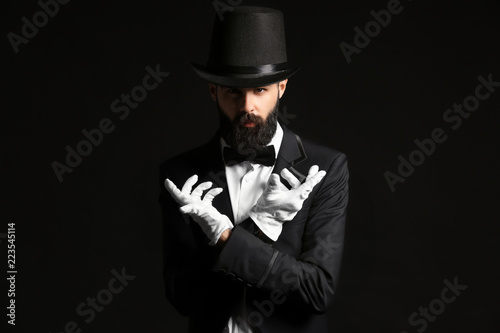 Male magician on dark background
