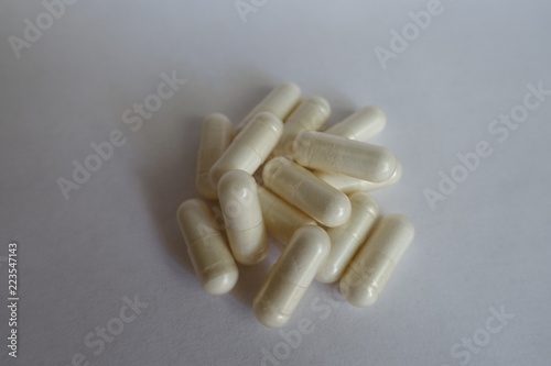 White capsules of ALCAR on neutral background photo