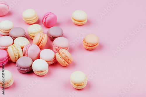 Different types of macaroons on pink background.