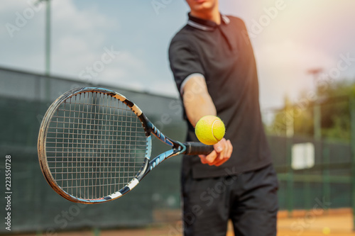 Close up of man playing tennis and beating the ball with a racket. © Akaberka
