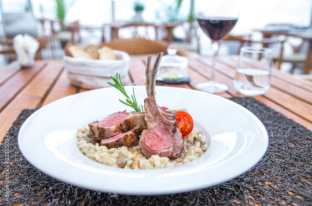 Roasted lamb chops with chanterelles and vegetables on decorated table Roasted lamb chops with chanterelles and vegetables on decorated table