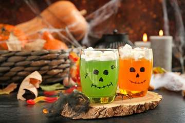 Creative glasses with jelly dessert prepared for Halloween party on dark table
