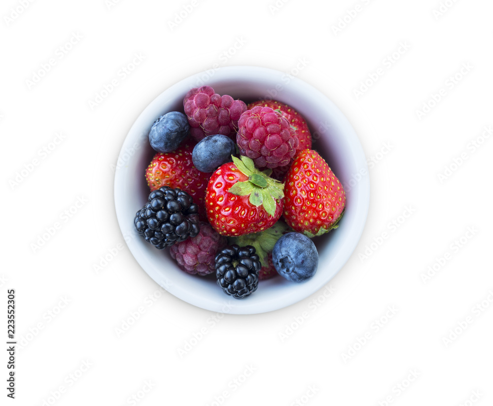 Top view. Fruits and berries in bowl isolated on white background. Ripe raspberries, strawberries, blackberries and blueberries. Background of mix fruits with copy space for text. 