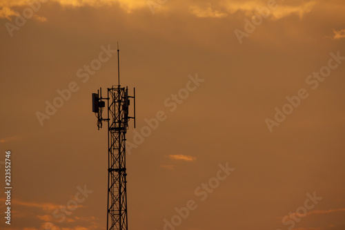 Silhouette of Signal tower with golden sky background.