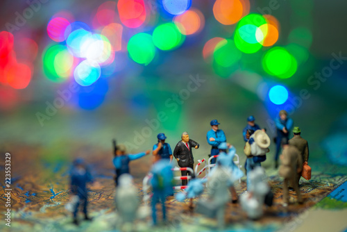 Miniature toy people concept US border patrols against a group of migrant from Mexico-blur bokeh light in the background.