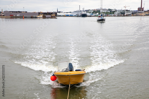 Looking from the stern of a 3-masted schooner at a dinghy pulled behind; on its way under motor from Turku to the Island of Aspö in Archipelago National Park (Skärgårdshavet nationalpark), Finland. photo