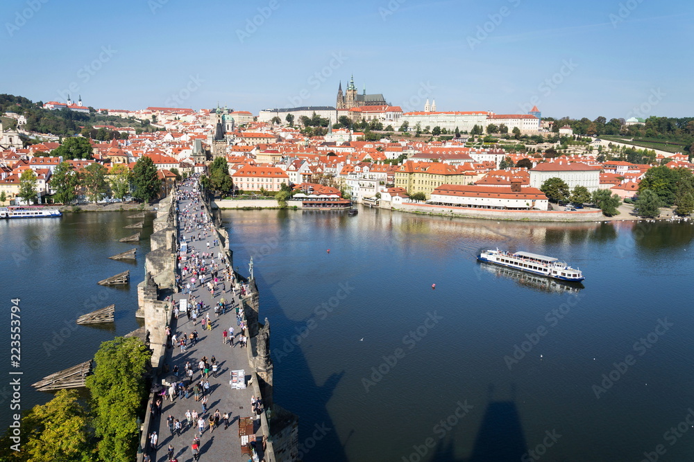 Tourists walk on Charles Bridge over Vltava River, UNESCO World Heritage Site, Prague, Czech Republic, sunny summer day