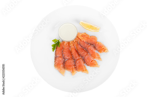 Cold appetizer before alcohol, salmon fillet salted with sauce wasabi, 6 pieces, mayonnaise, sour cream, lemon slice and parsley branch on plate, white isolated background view from above For the menu