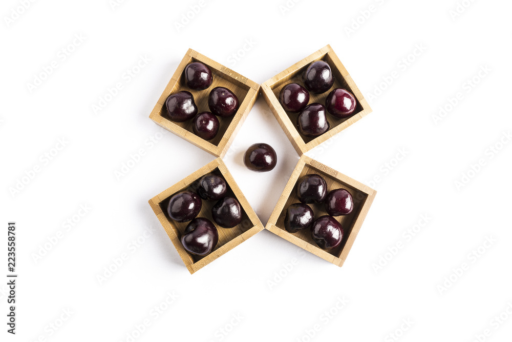 group of fresh red cherries in a wooden square bowls on a white background
group of fresh red cherries in a wooden square bowls on a white background