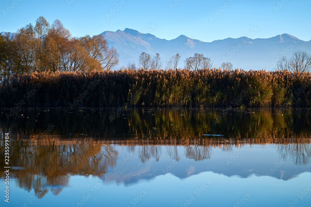 Beautiful autumn landscape with mountains and river reflection 