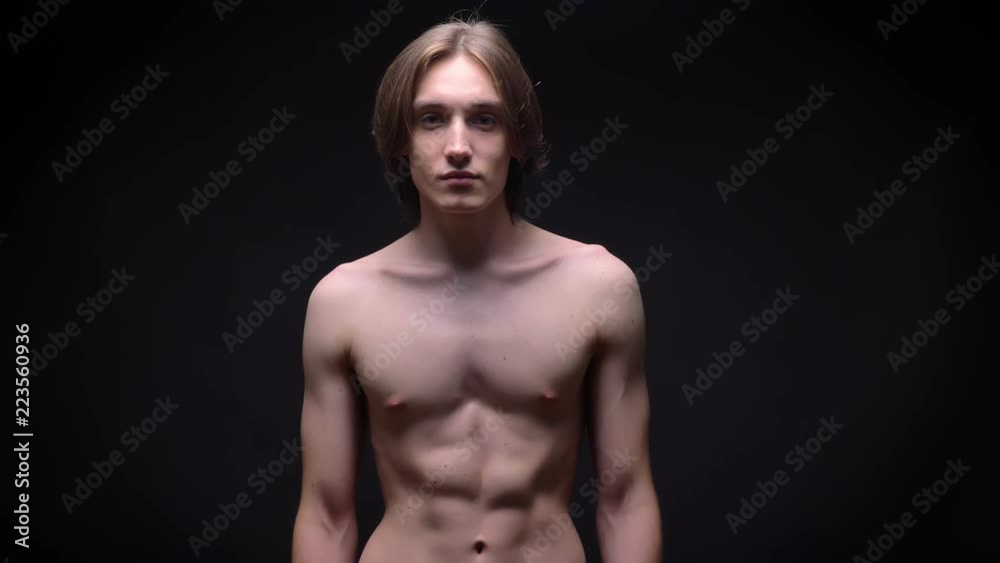 muscular bare young white sportsman looking at the camera with power concentrated on black background muscular bare young white sportsman looking at the camera with power concentrated on black background
