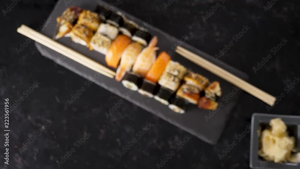 Top view zoom in on delicious traditional japanese sushi rolls on black stone plate Top view zoom in on delicious traditional japanese sushi rolls on black stone plate