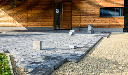 Fotografia Laying gray concrete paving slabs in house courtyard driveway patio