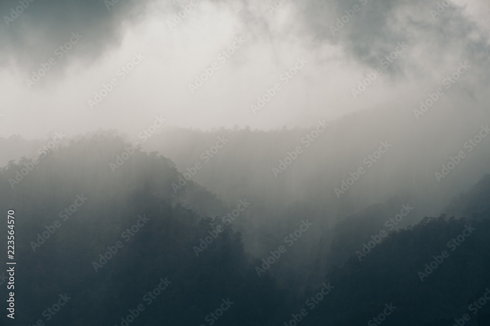 Landscape image of greenery rainforest hills on rainy day with cloudy sky background