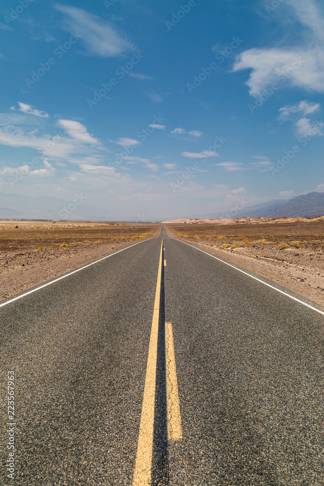 Looking along a long, straight road in Death Valley National Park, California