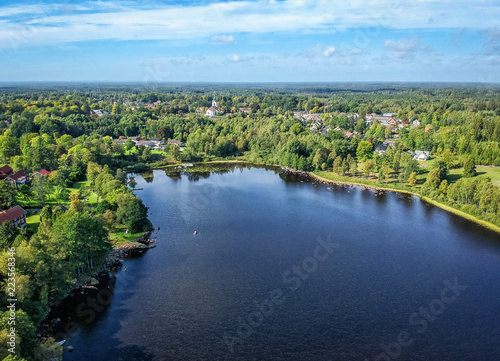 Aerial landscape over Swedish lake and village in September