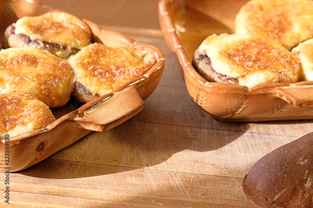 baked mushrooms with cheese on a wooden background