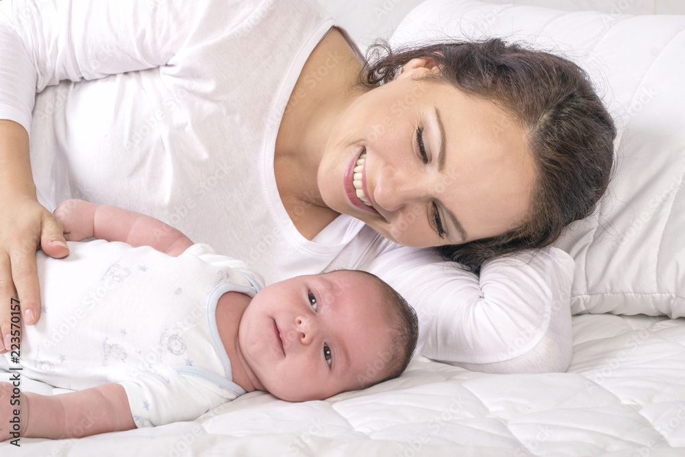 Mother and baby on a white bed Mother and baby on a white bed