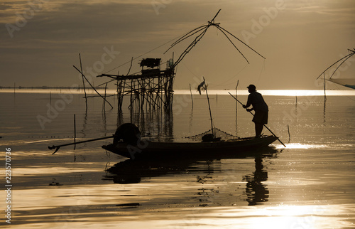 Local fisherman started his work early morning, in the golden sunrise in the wetland Talay Noi, Pattalung, Thailand.