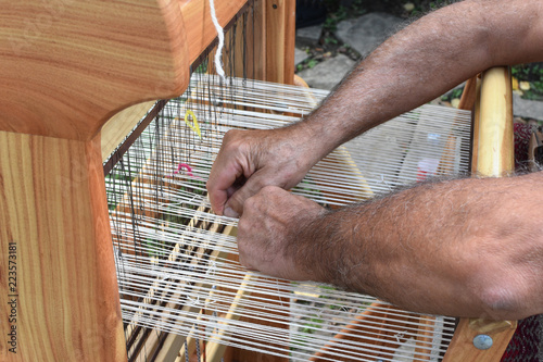 Tableau sur toile Hands of middle-aged man - craftsman weaver - working on wooden handloom, Etara