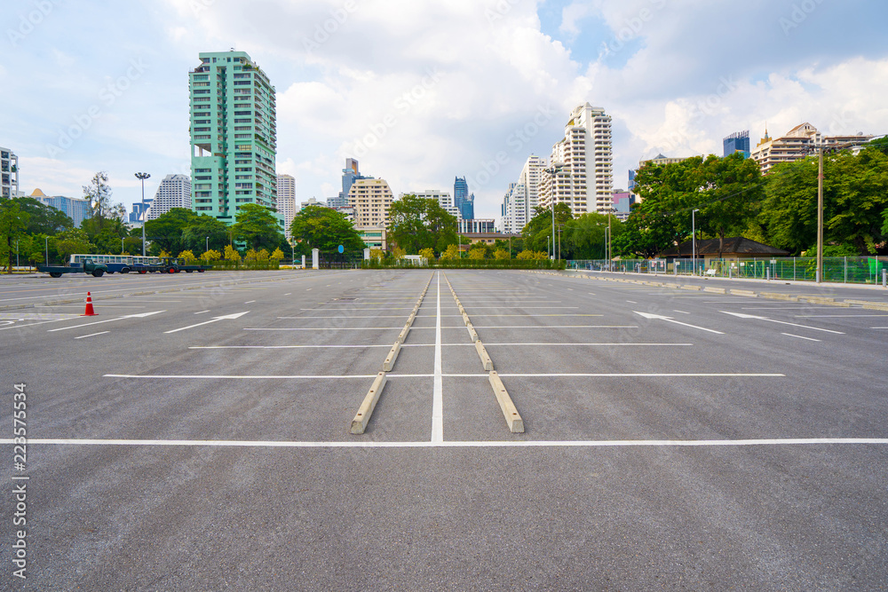 Empty parking lot with city in the background and beautiful blue sky Empty parking lot with city in the background and beautiful blue sky