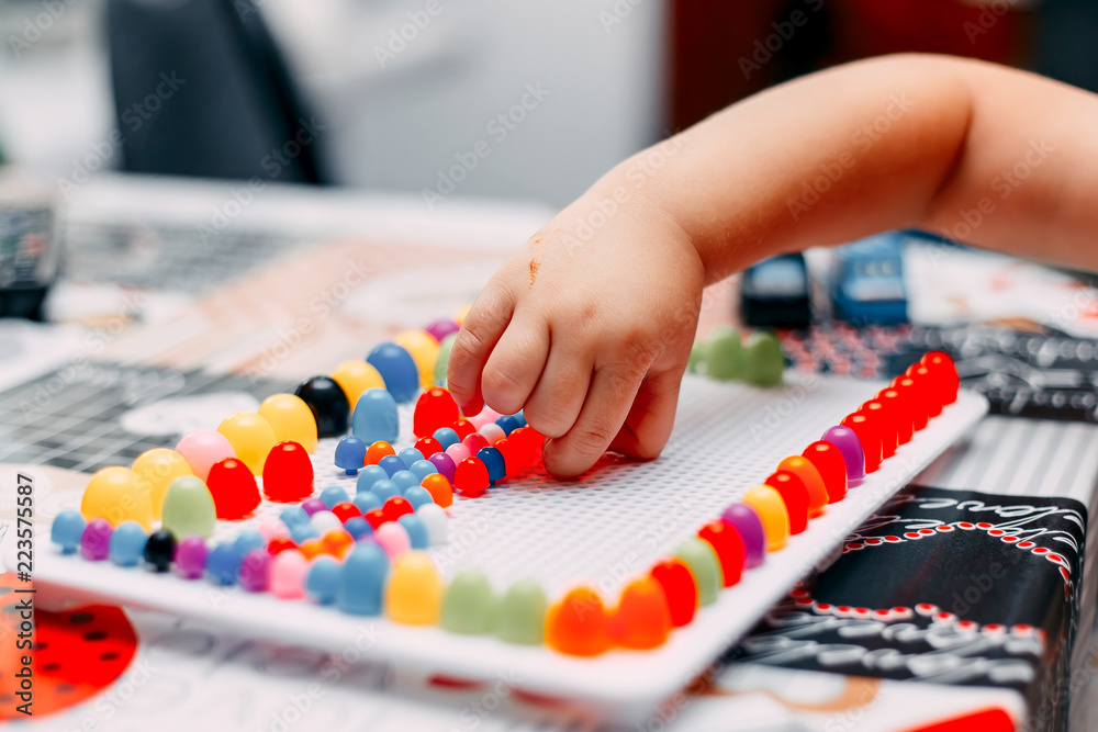 little boy play board game on table mosaic colored