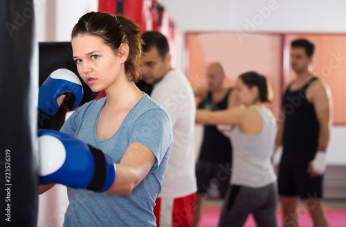 Portait of girl which is beating a boxing bag