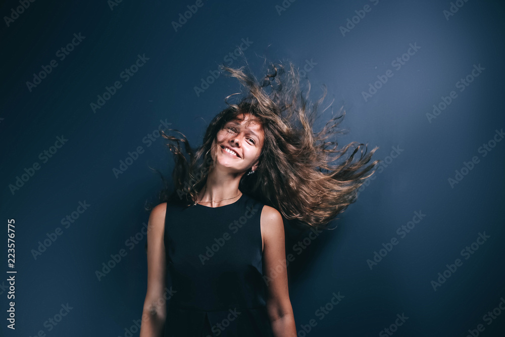 long-haired charming young woman in studio on a blue background dancing and posing. demonstration of freedom and recklessness. long-haired charming young woman in studio on a blue background dancing and posing. demonstration of freedom and recklessness.