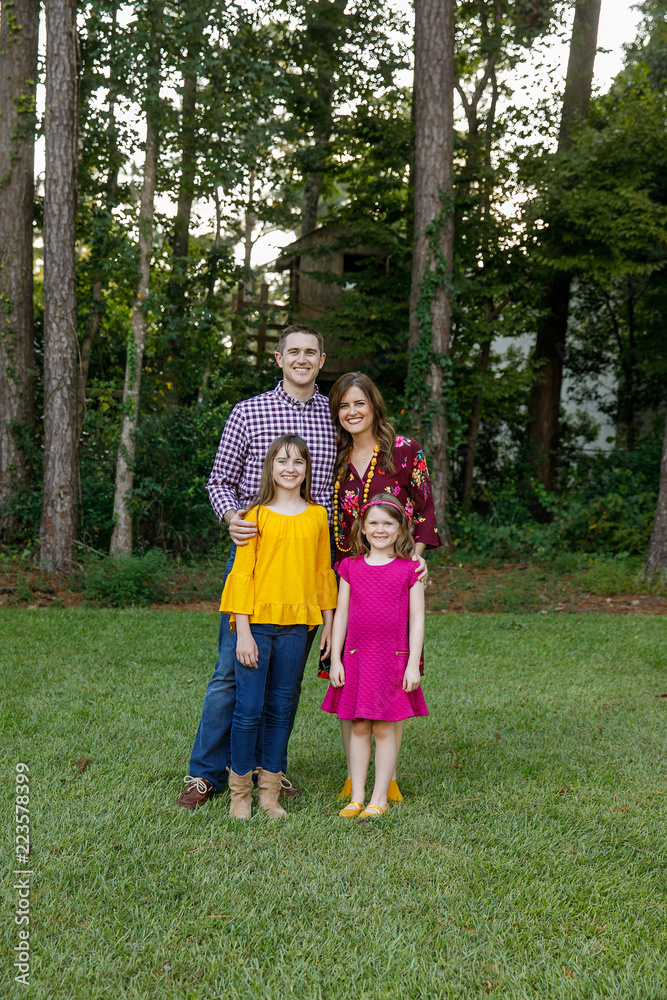 Fototapeta premium Nuclear Family of Four with Daughters Outside in their Backyard