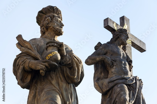 Statue of Holy Savior with Saints Cosmas and Damian detail on Charles Bridge, Prague, Czech Republic photo