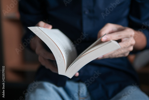 Man in blue shirt reading a book
