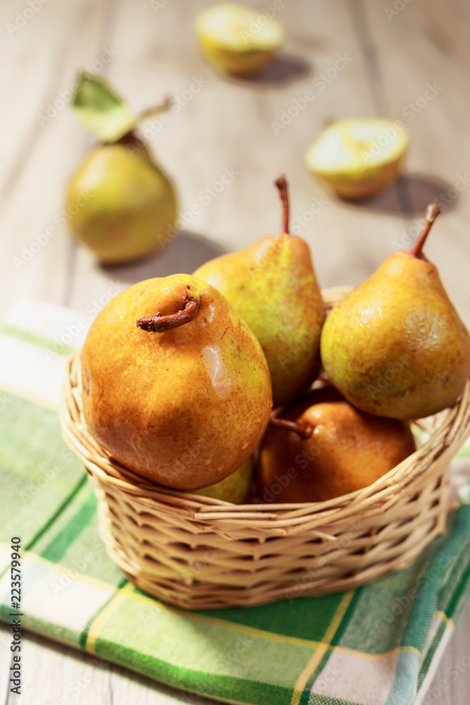 Fresh pears in wicker basket on wood table