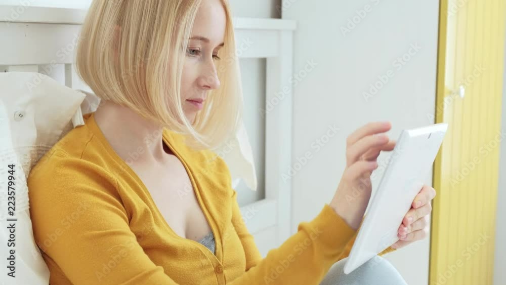 Portrait of attractive blonde Caucasian woman smiling and using digital tablet. Portrait of attractive blonde Caucasian woman smiling and using digital tablet.