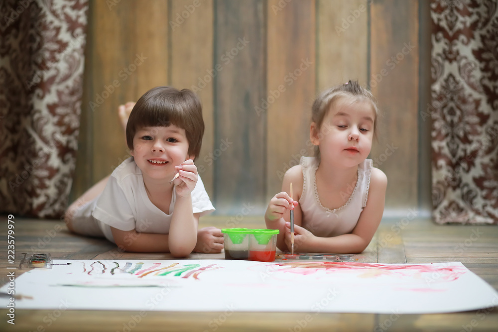 Little children paint on a large sheet of paper Little children paint on a large sheet of paper