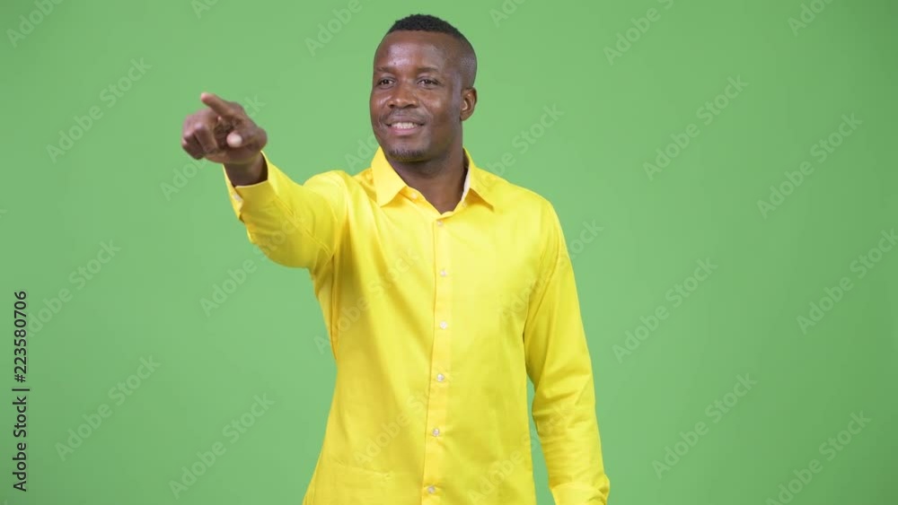Young happy African businessman pointing finger Young happy African businessman pointing finger