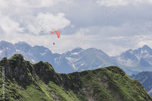 Gleitschirmflieger schwebt über den Alpen